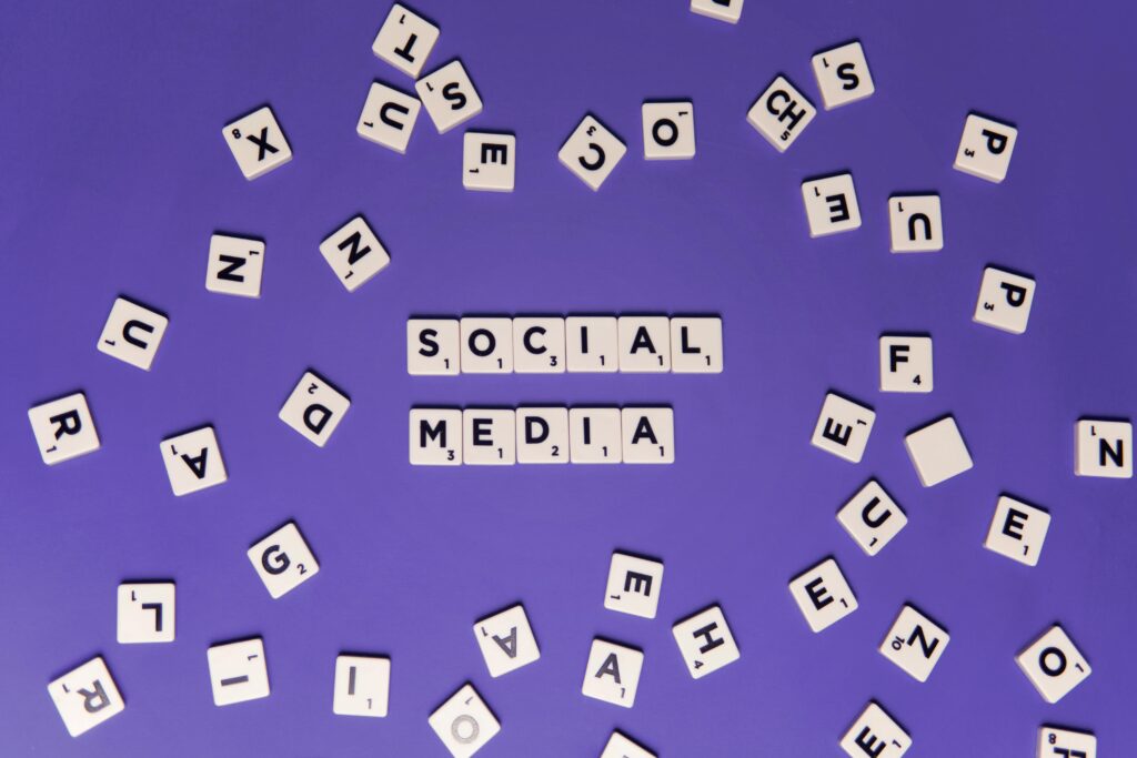 Creative composition of scrabble tiles spelling 'Social Media' on a purple background.
